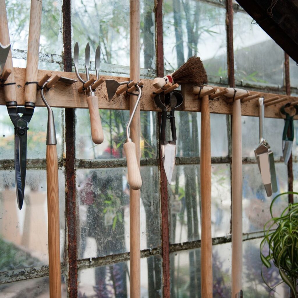 garden tools hanging from a wall in shed